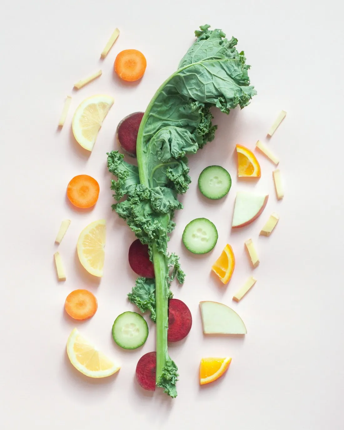 Verdure fresche e frutta disposte con leggerezza su un fondo chiaro