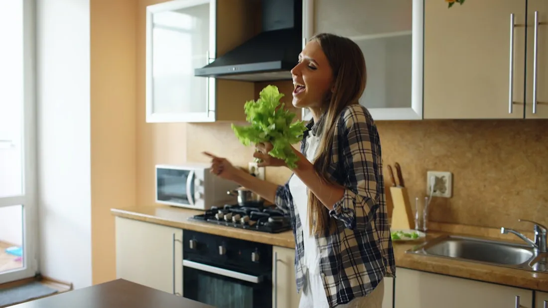 Elisa in cucina con della verdura fresca in mano